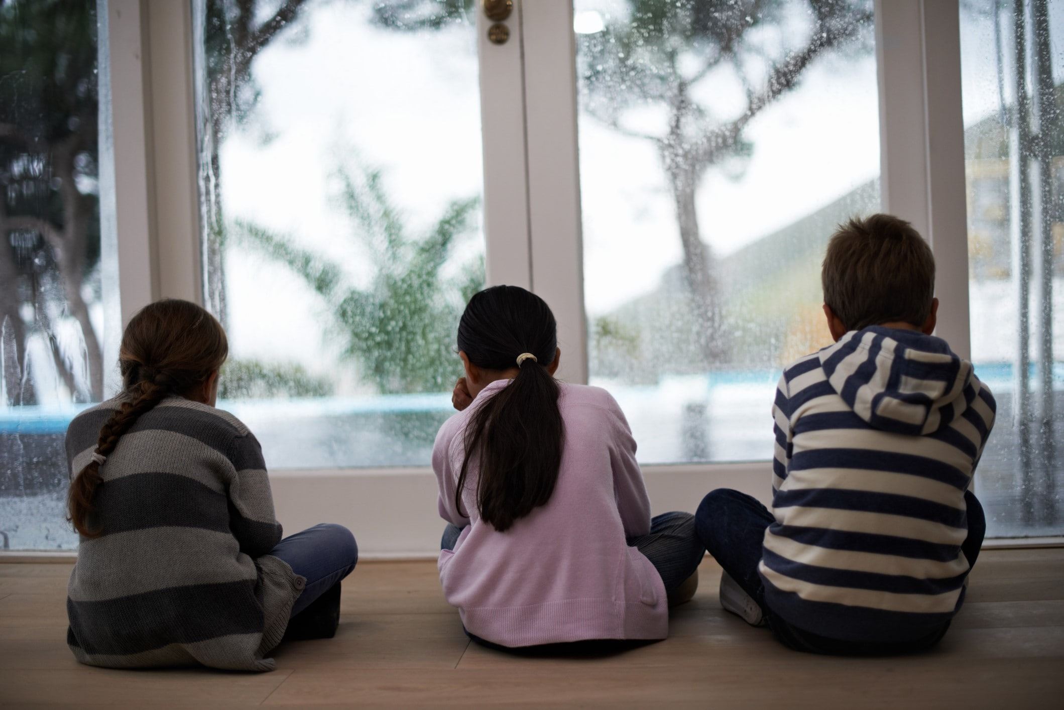 Three children looking outside the door